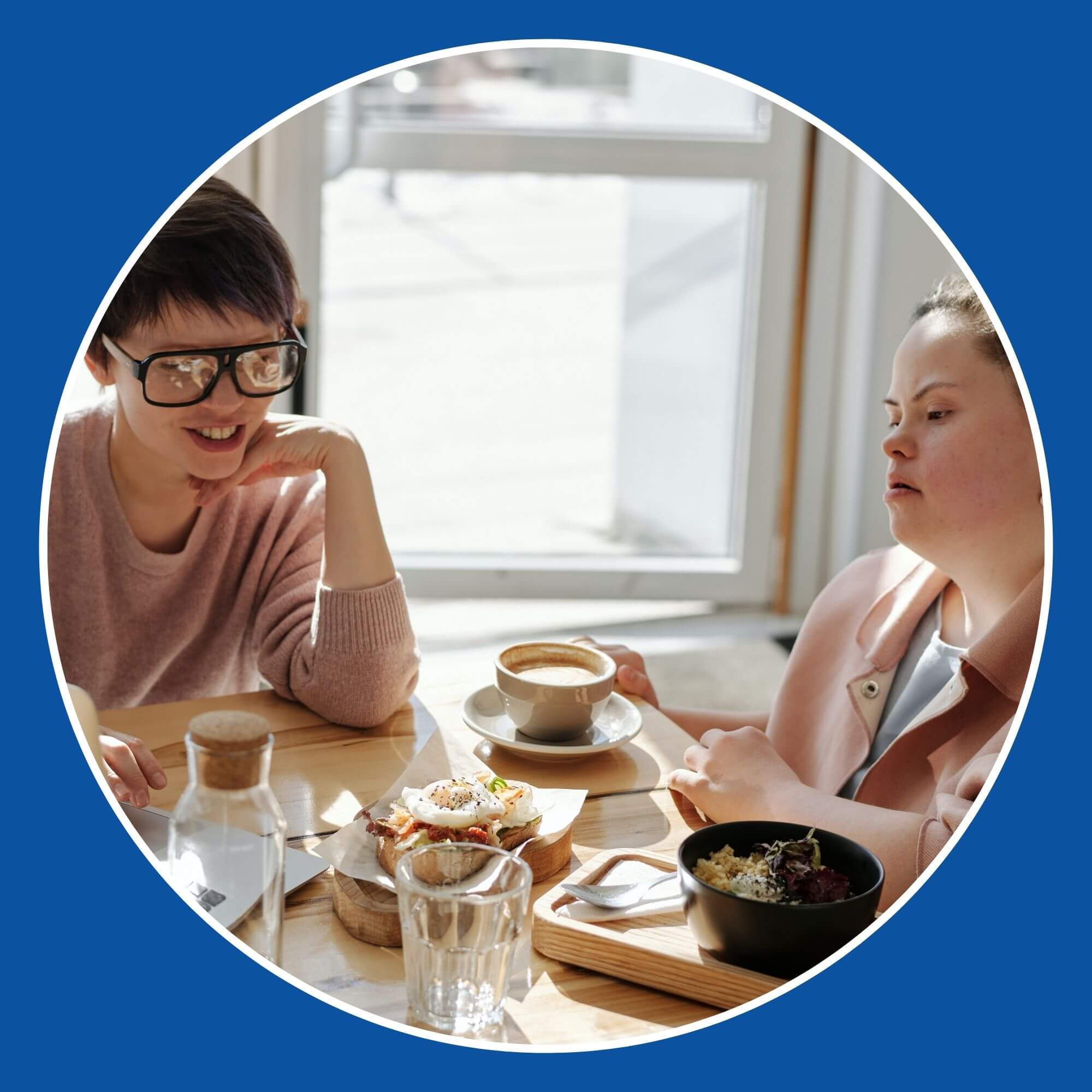 Image showing two ladies sitting at a table with coffee and a laptop. Image from Pexels (Photographer - Cliff Booth)