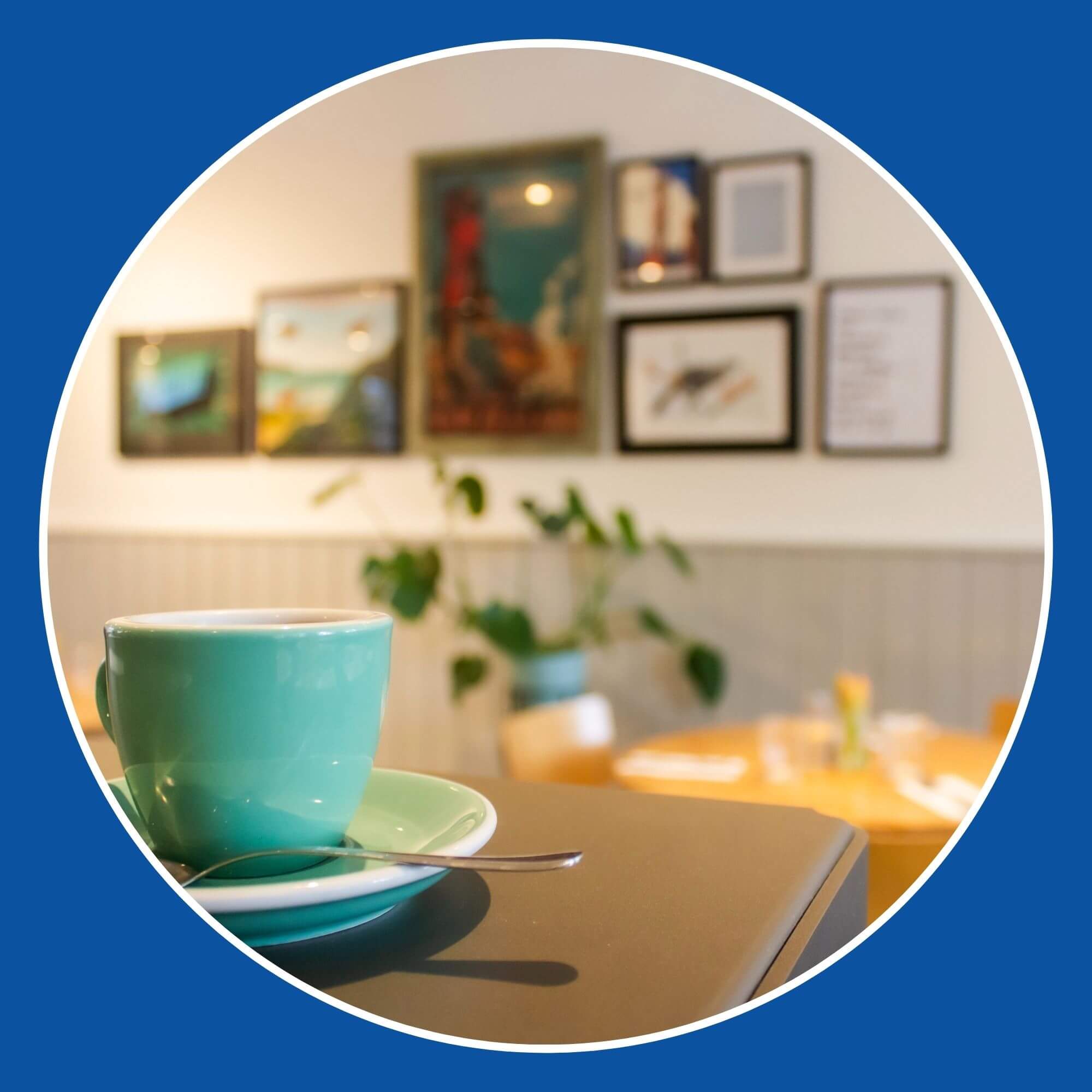 Photo showing a cup and saucer on a table in a cafe. Image from Unsplash (Photographer - Louis Hansel)